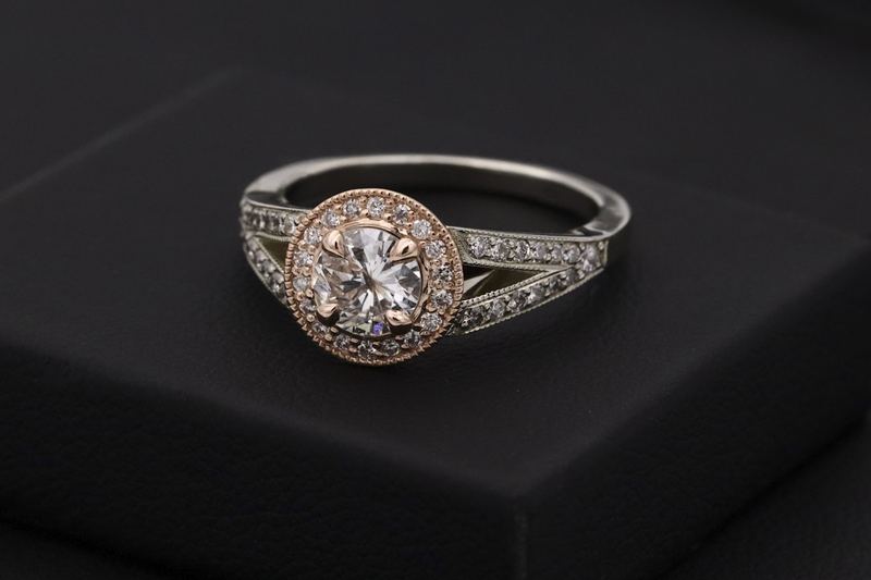 Diamond halo engagement ring on dark surface
